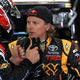 Kimi Räikkönen speaks to a mechanic in a garage at a NASCAR race in 2011